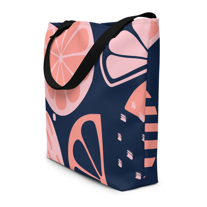 Large tote bag with navy blue background and pink coral grapefruit slice print, black handles