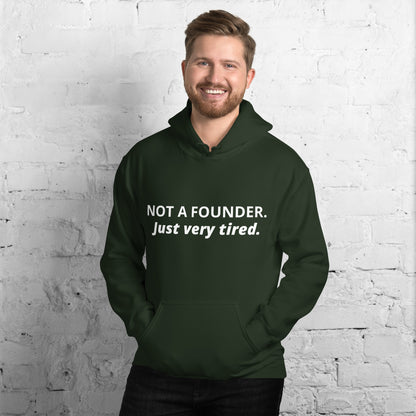 Forest green hoodie with white text 'NOT A FOUNDER.' and italic 'Just very tired.' worn by model