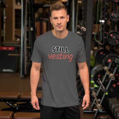 Male model wearing charcoal t-shirt with bold white 'STILL' and rust-orange script 'vesting'