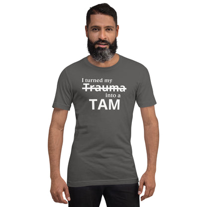 Asphalt grey t-shirt with white text 'I turned my' and strikethrough 'Trauma', 'into a' and bold 'TAM' below